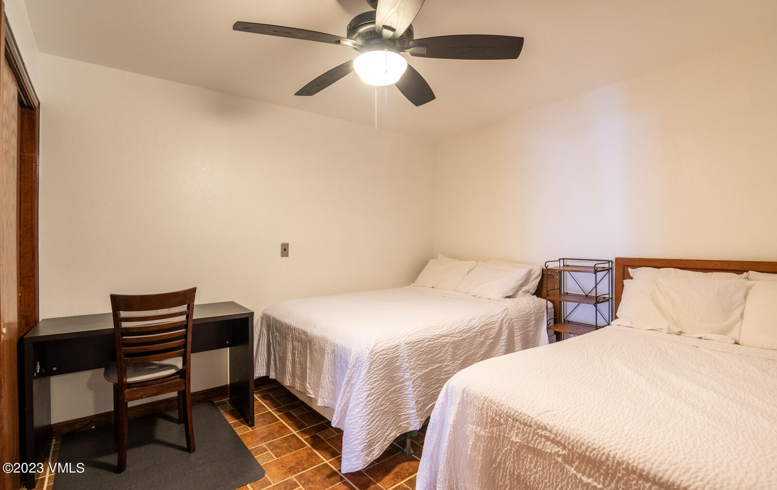 137 Benchmark Road, Unit 209 Avon, CO 81620 - Photo 11 of 20 a bedroom with two beds and a chandelier