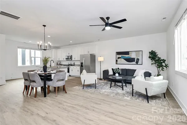 a living room with furniture dining table a chandelier and a rug