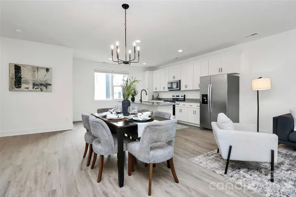 a view of a dining room with furniture a chandelier and wooden floor