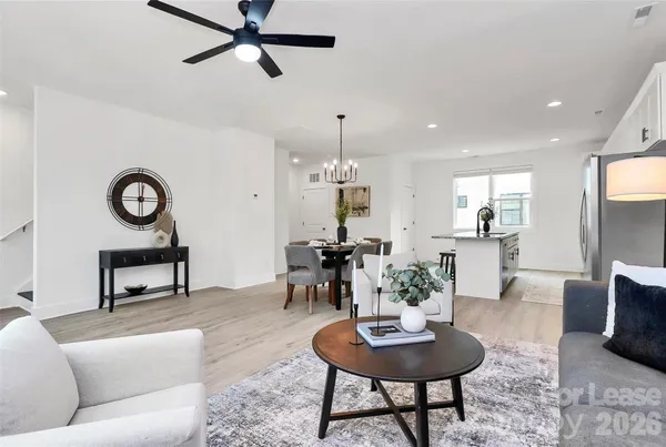 a living room with furniture and a view of kitchen