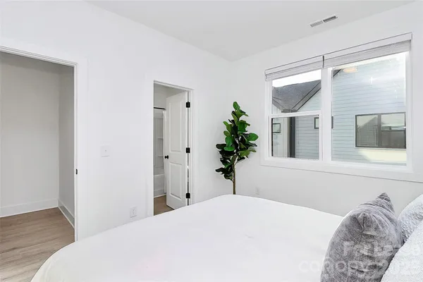 a bedroom with a bed and a potted plant
