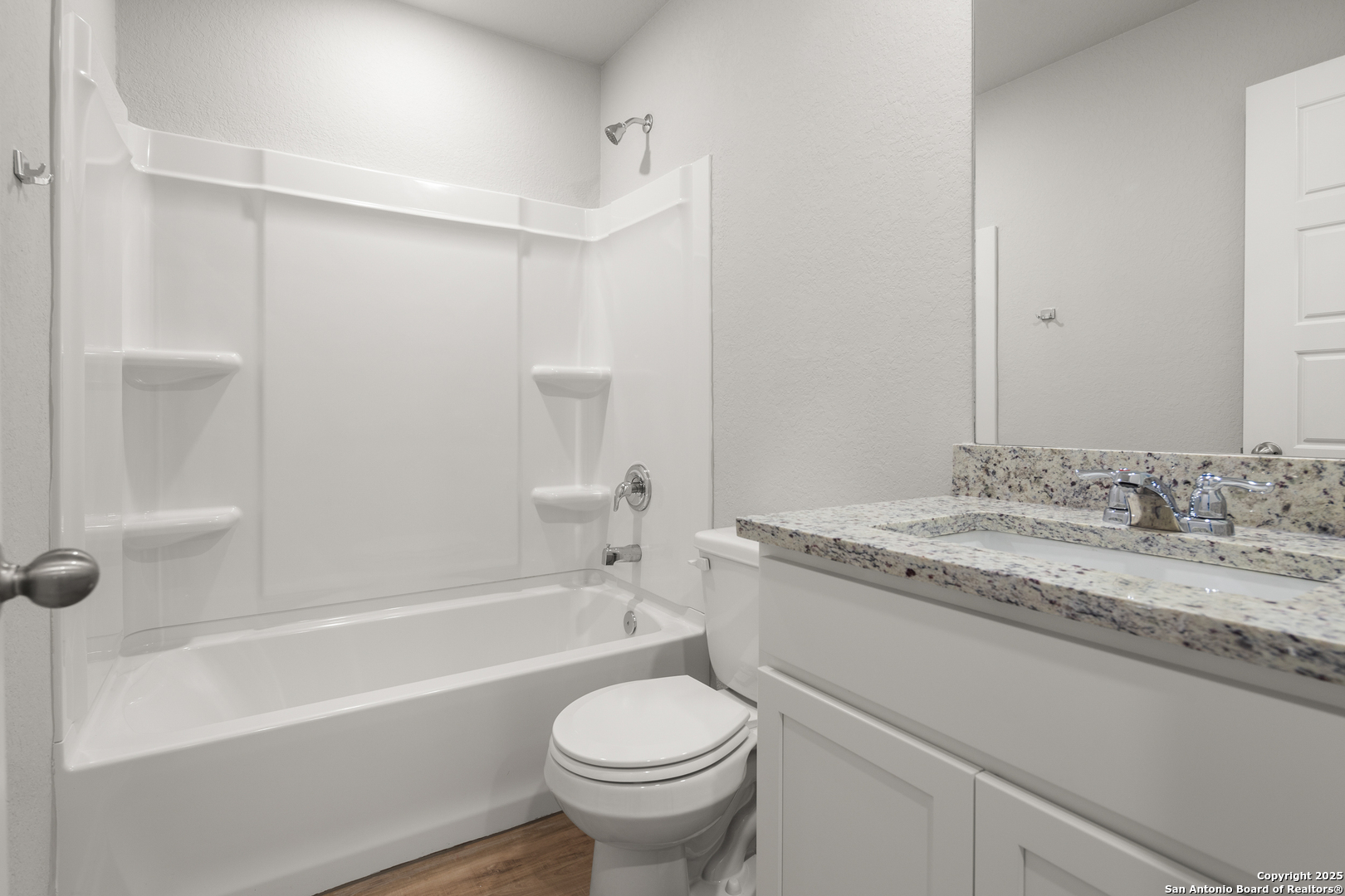 3928 Abbott Pass, Unit 101 St. Hedwig, TX 78152 - Photo 11 of 17 a bathroom with a granite countertop toilet a sink and a bathtub