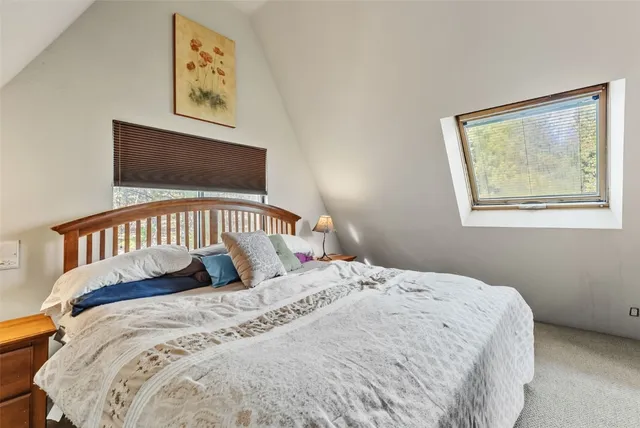 a bedroom with a bed and a flat tv screen on the dresser