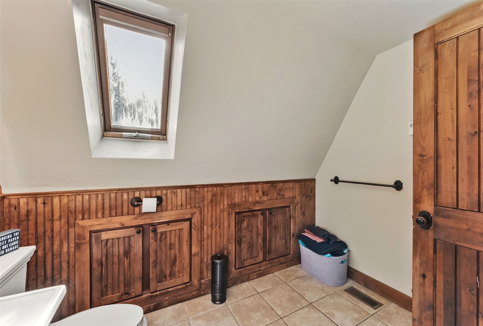 511 Vail Circle Dillon, CO 80435 - Photo 37 of 47 Bathroom with lofted ceiling, light tile patterned floors, wood walls, and a skylight