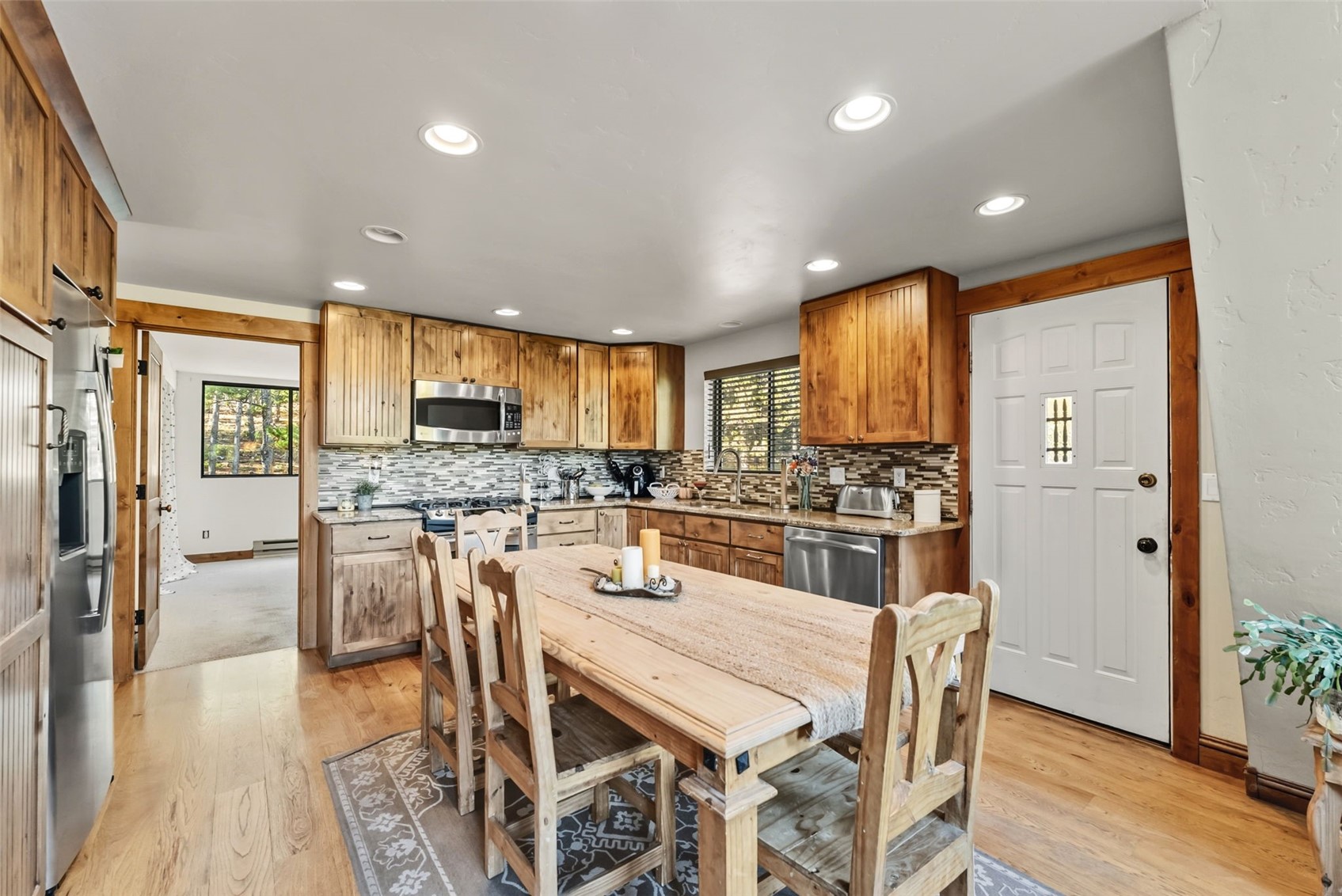 511 Vail Circle Dillon, CO 80435 - Photo 10 of 47 a kitchen with stainless steel appliances kitchen island granite countertop a refrigerator a stove a sink dishwasher with a dining table and chairs