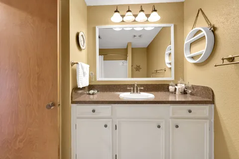 a bathroom with a granite countertop sink toilet and shower
