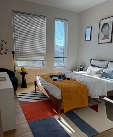 a bedroom with a bed and wooden floor