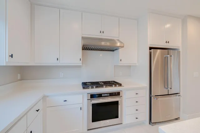 a kitchen with white cabinets and white appliances