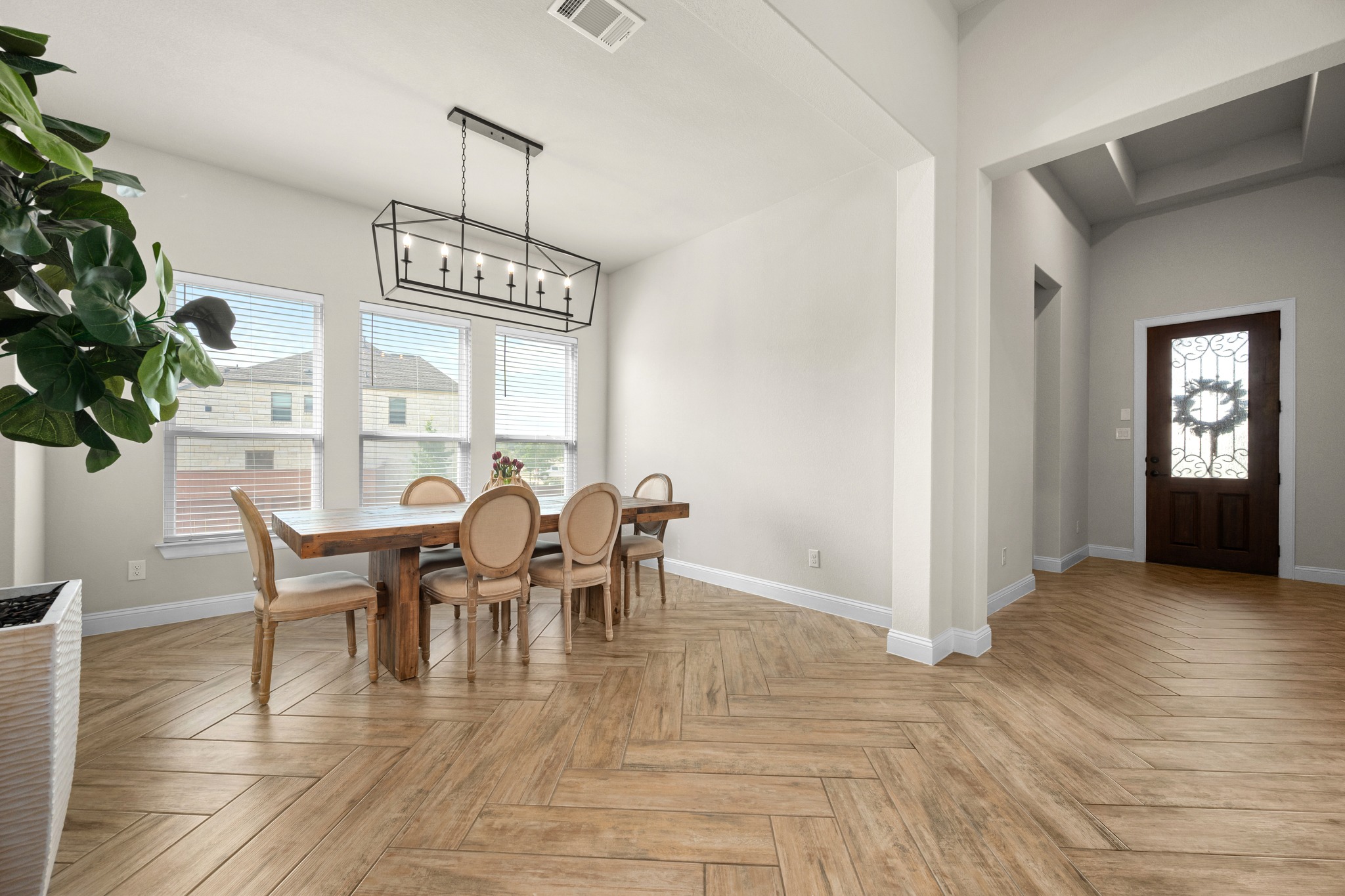 2100 Highland Ridge Road Georgetown, TX 78628 - Photo 6 of 30 Herringbone pattern wood-look flooring extends through this naturally illuminated dining area, leading to an ornate foyer.