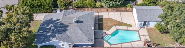 an aerial view of a house with a yard and large trees