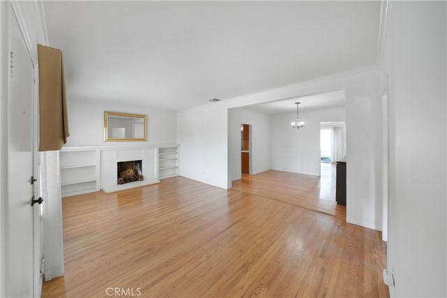 a view of a livingroom with wooden floor and a fireplace