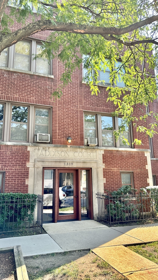 front view of a brick house with a yard
