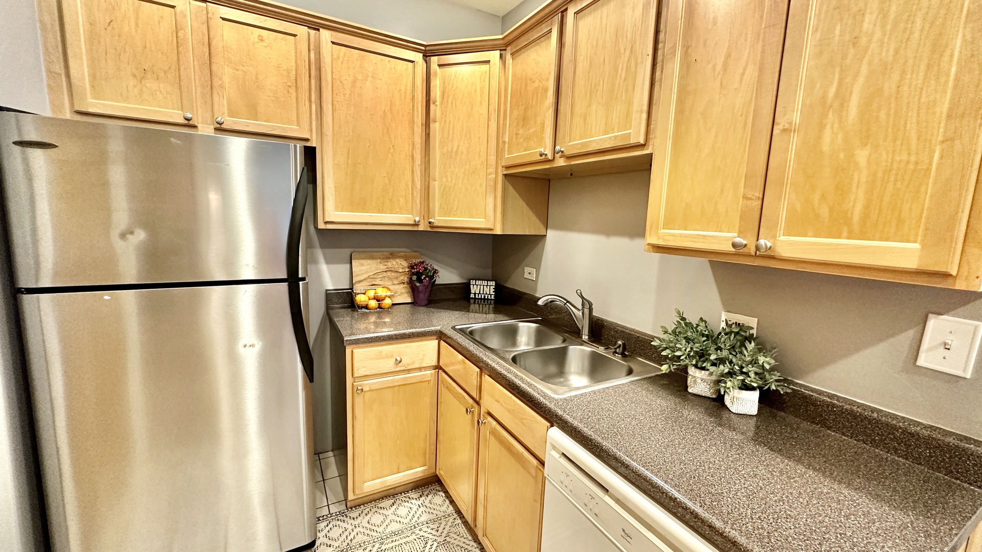 1319 West Addison Street, Unit 1A Chicago, IL 60613 - Photo 14 of 20 a kitchen with stainless steel appliances granite countertop a refrigerator and a sink