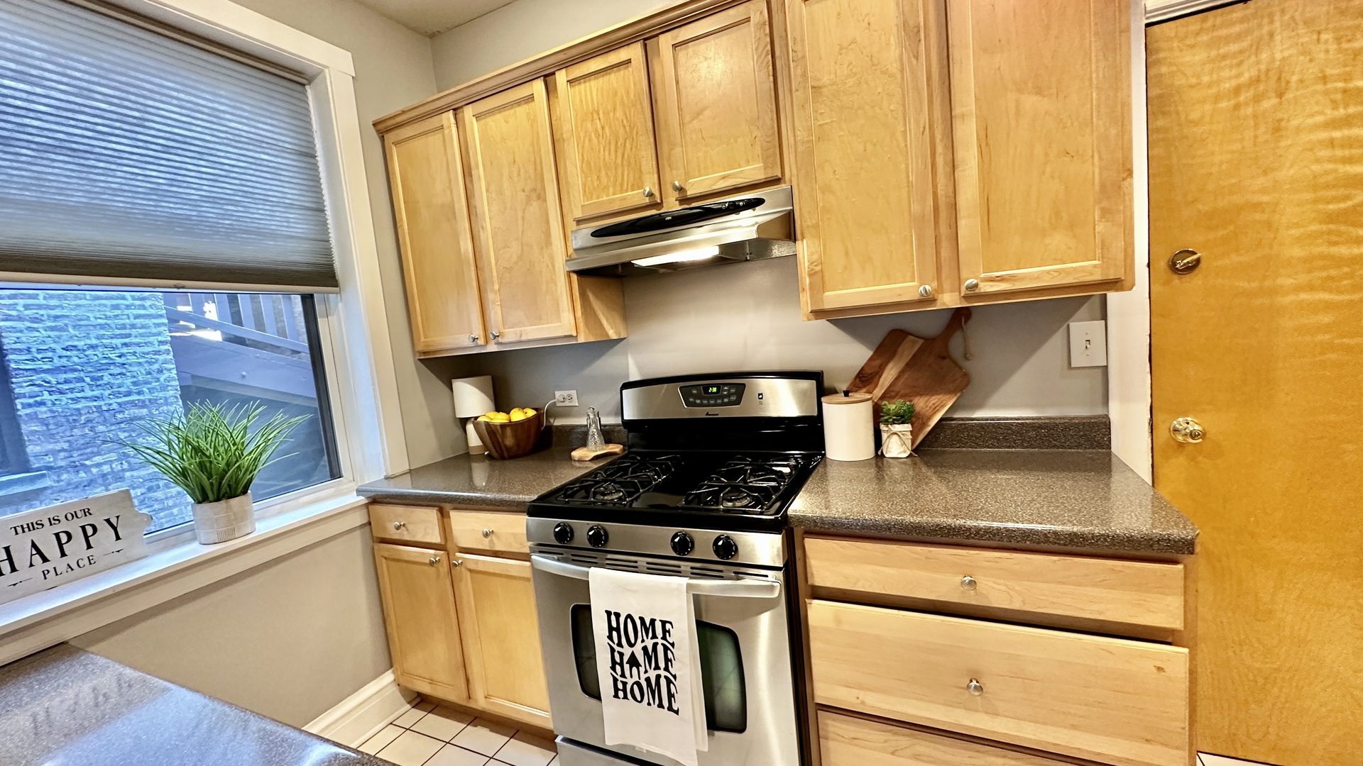 1319 West Addison Street, Unit 1A Chicago, IL 60613 - Photo 15 of 20 a kitchen with stainless steel appliances granite countertop a stove a sink and a microwave
