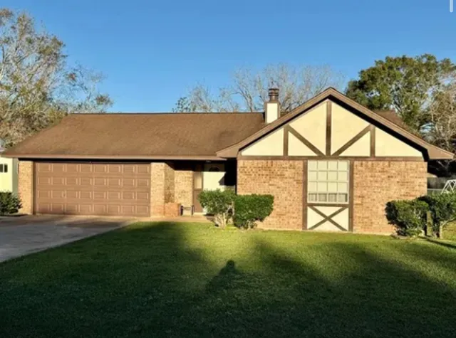 a view of house with backyard and garden