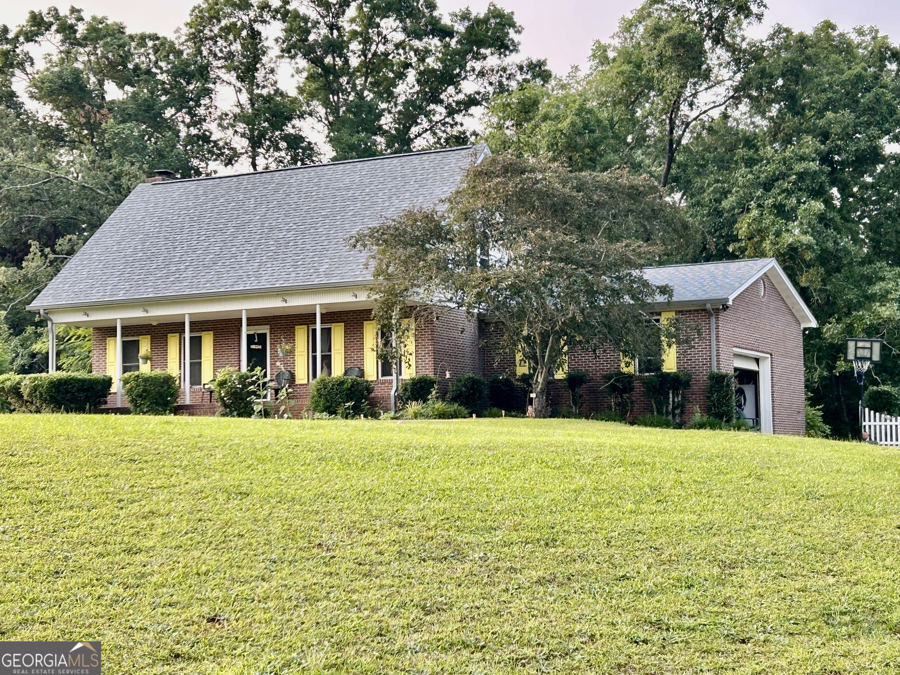 a front view of a house with a yard and trees