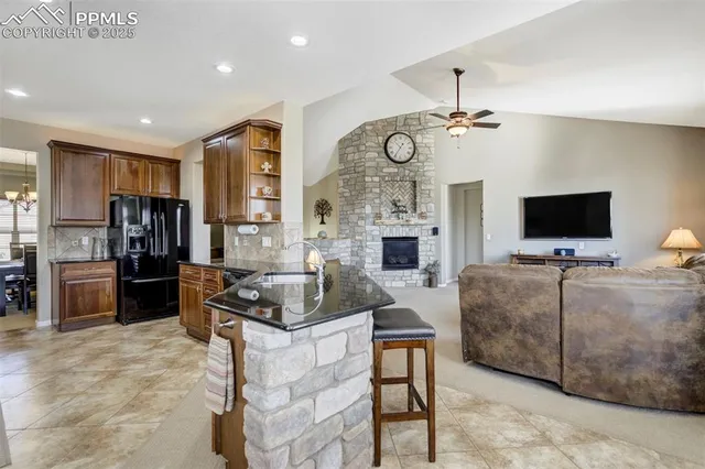 a living room with furniture a flat screen tv and kitchen view