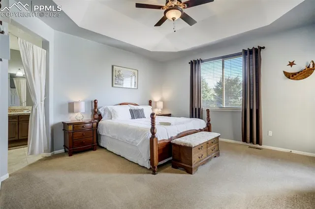 a spacious bedroom with a bed and a chandelier