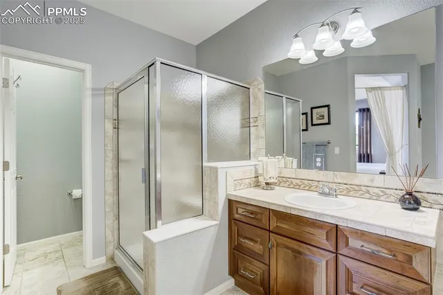 a bathroom with a granite countertop sink a mirror and a shower