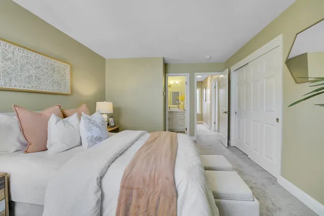 a spacious bedroom with a bed a mirror and a flat screen tv