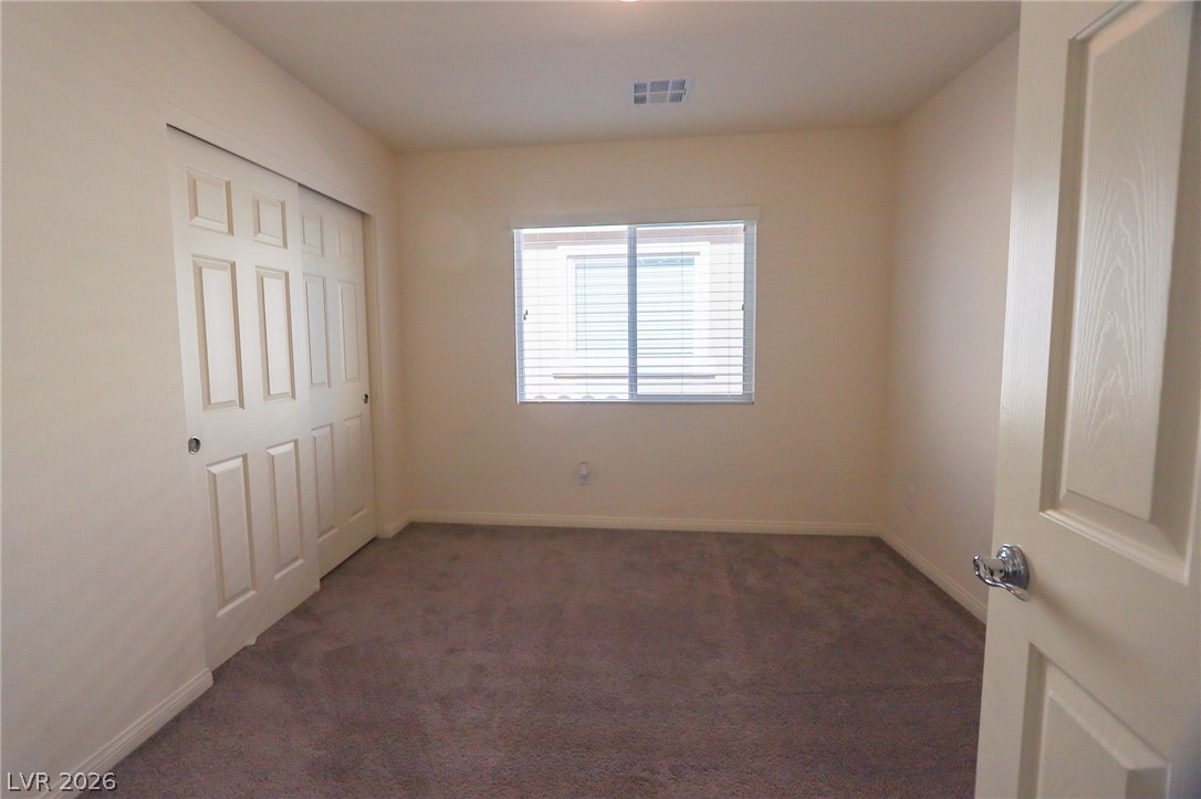 6418 Jackson Spring Road Las Vegas, NV 89118 - Photo 14 of 20 A well-lit bedroom featuring a spacious closet and neutral decor.