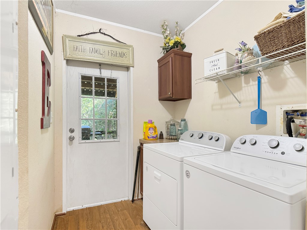 10134 Cobb Branch Road Franklin, TX 77856 - Photo 20 of 23 Laundry area featuring crown molding, light wood-style floors, cabinet space, and washing machine and clothes dryer