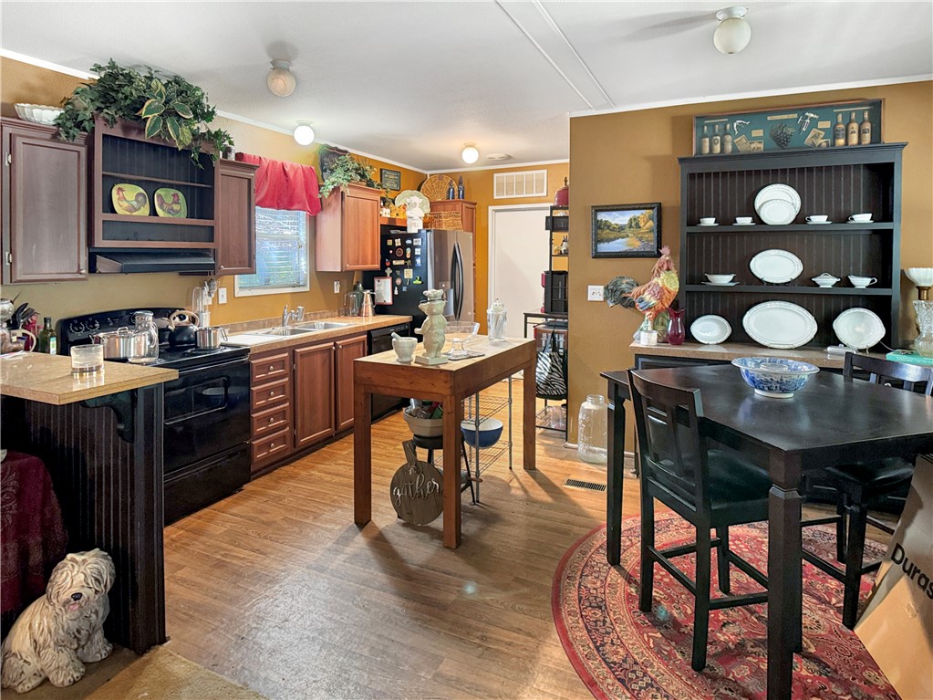 10134 Cobb Branch Road Franklin, TX 77856 - Photo 7 of 23 Kitchen featuring black range with electric stovetop, light countertops, ornamental molding, open shelves, and light wood-type flooring