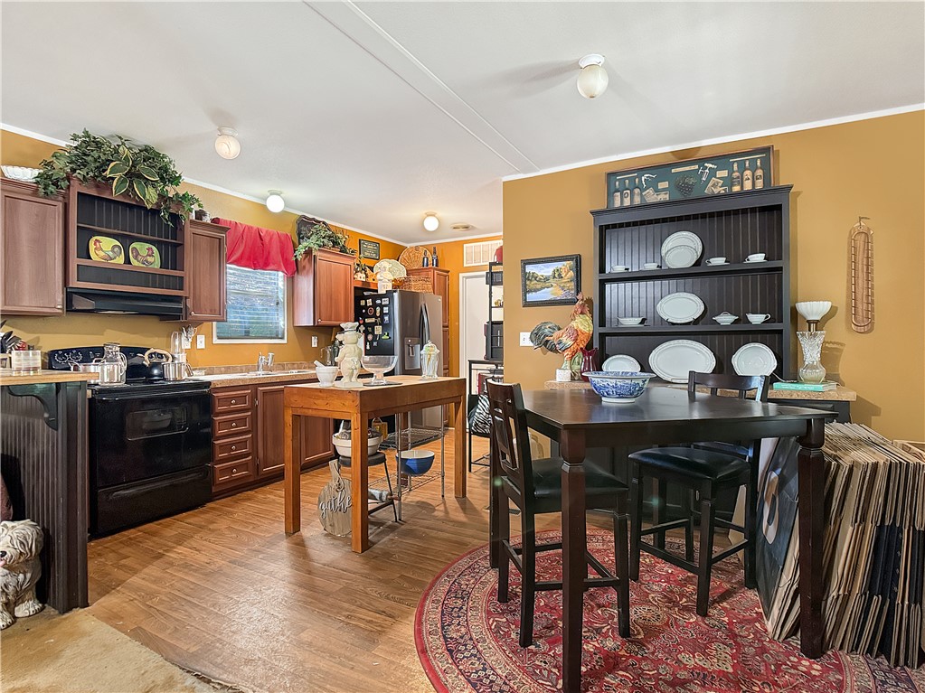 10134 Cobb Branch Road Franklin, TX 77856 - Photo 10 of 23 Kitchen featuring electric range, light countertops, light wood-type flooring, open shelves, and stainless steel fridge