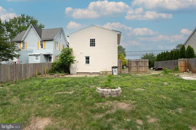 a view of backyard of house with wooden fence