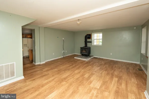 a view of a livingroom with wooden floor and a bathroom