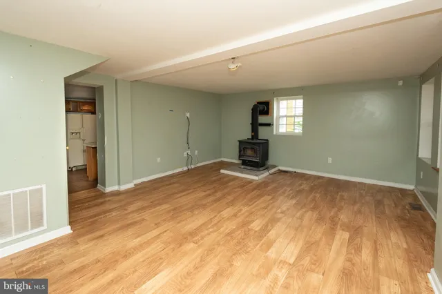 a view of a livingroom with wooden floor and a bathroom