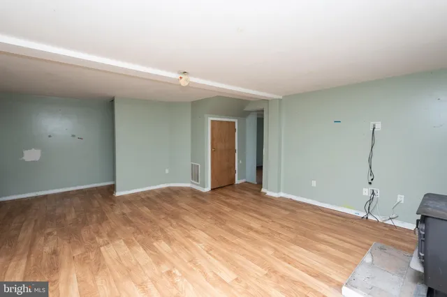 a view of a big room with wooden floor and windows