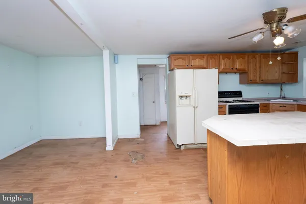 a kitchen with a stove a refrigerator and a sink with wooden floor