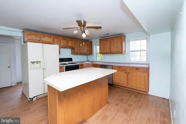 a kitchen with a refrigerator a sink dishwasher and a stove with wooden floor