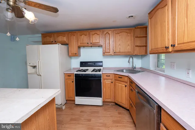 a kitchen with stainless steel appliances granite countertop a refrigerator sink and stove