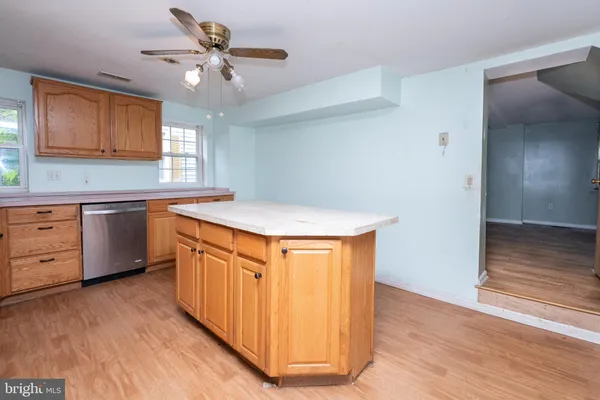 a kitchen with stainless steel appliances granite countertop a sink cabinets and wooden floor