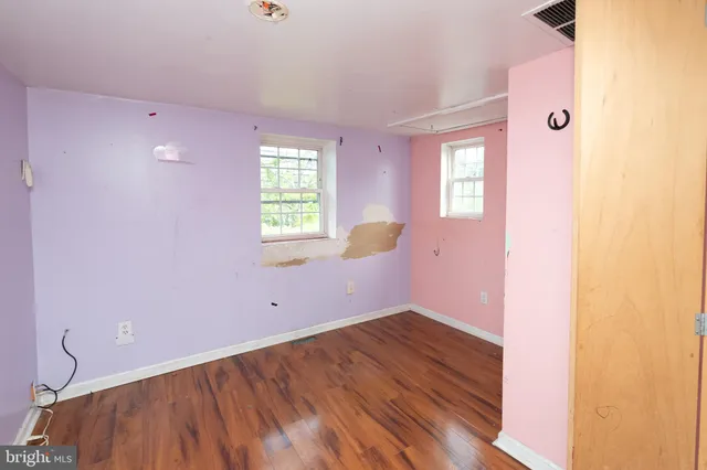 a view of empty room with wooden floor