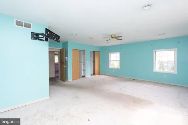 an empty room with windows and closet