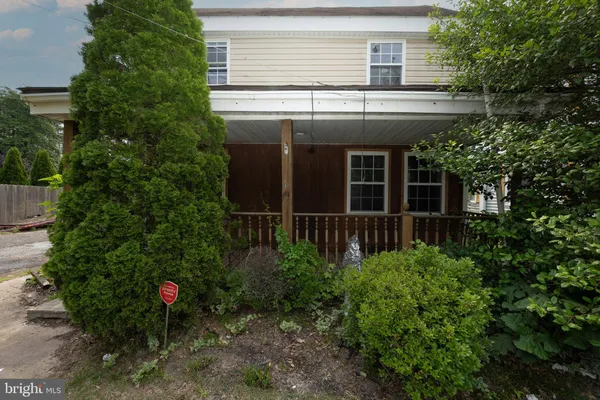 a view of a house with potted plants and a tree