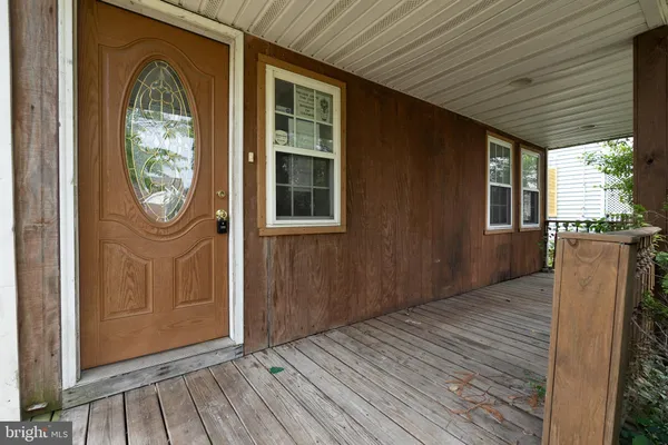 an empty room with wooden floor a ceiling fan and windows