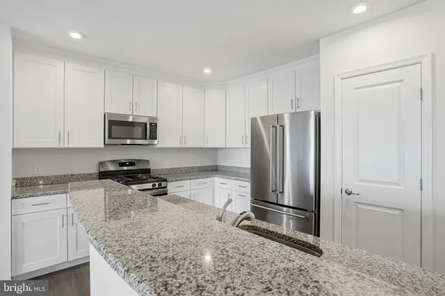 a kitchen with stainless steel appliances granite countertop a refrigerator stove and sink