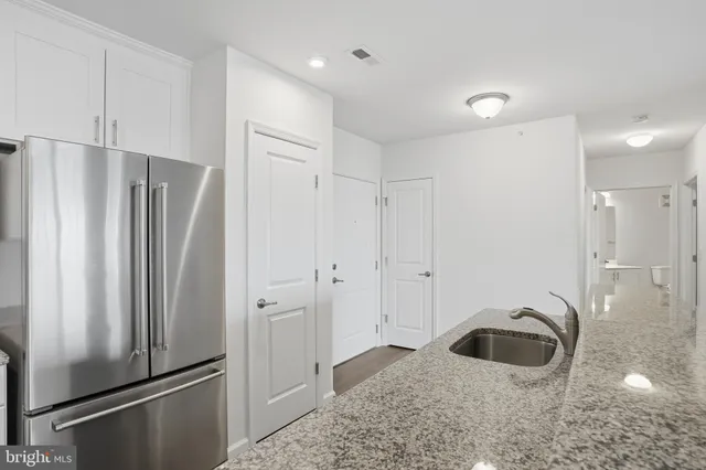 a kitchen with stainless steel appliances granite countertop a refrigerator and a sink
