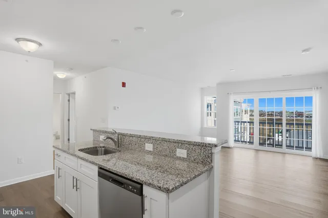 a bathroom with a granite countertop sink and a large mirror