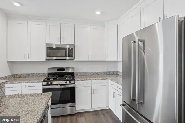 a kitchen with white cabinets and stainless steel appliances