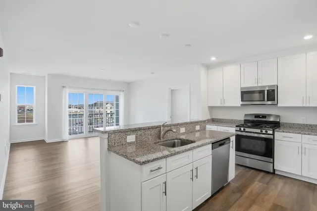 a kitchen with stainless steel appliances granite countertop a sink stove and wooden floor
