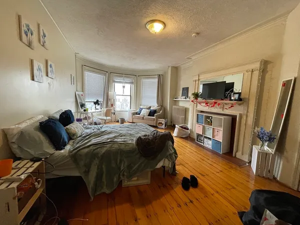 a spacious bedroom with a bed and a flat screen tv