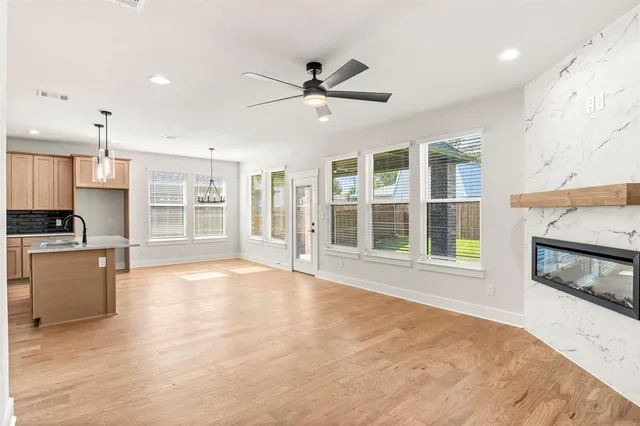 a view of an empty room with a kitchen and a window