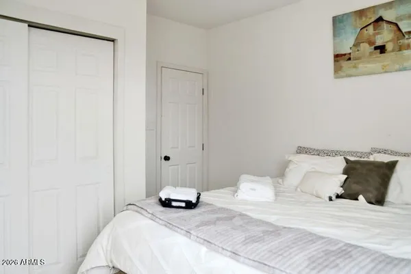 a bedroom with a bed and a painting on the wall