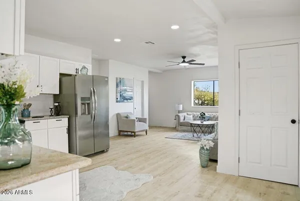 a kitchen with stainless steel appliances kitchen island granite countertop a refrigerator a stove a sink a dining table and chairs