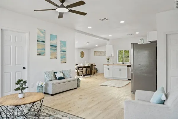 a living room with furniture and a view of kitchen